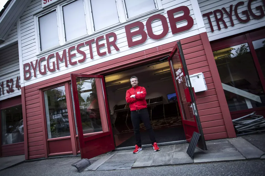Bygggmester bobs daglige leder forran ingang til butikk