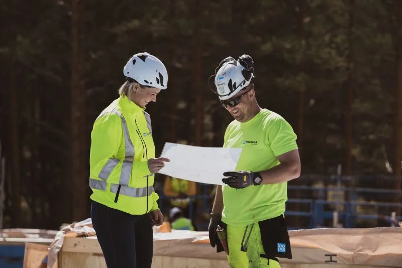 to taktekkere ser på en arbeidsplan og smiler